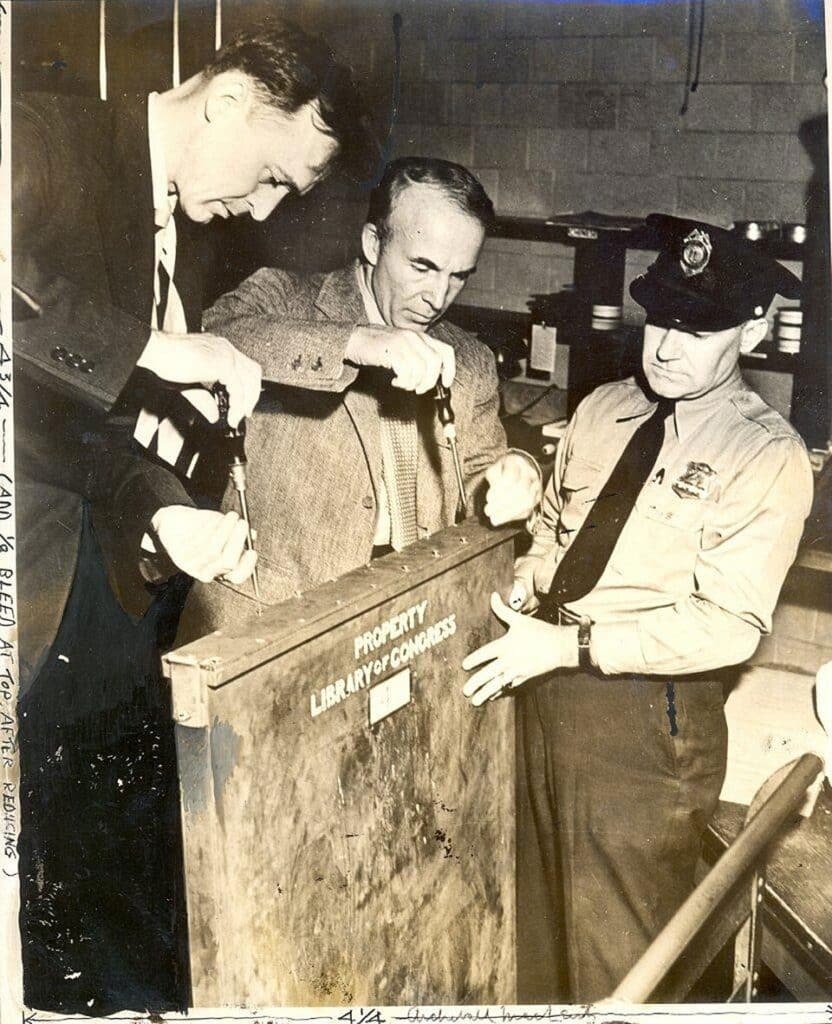 Photograph of Archibald Macleish unboxing crate holding the Declaration of Independence and US Constitution after arriving back to the Library of Congress on 1 October 1944 after having been stored at the United States Bullion Depository at Fort Knox since 1941
